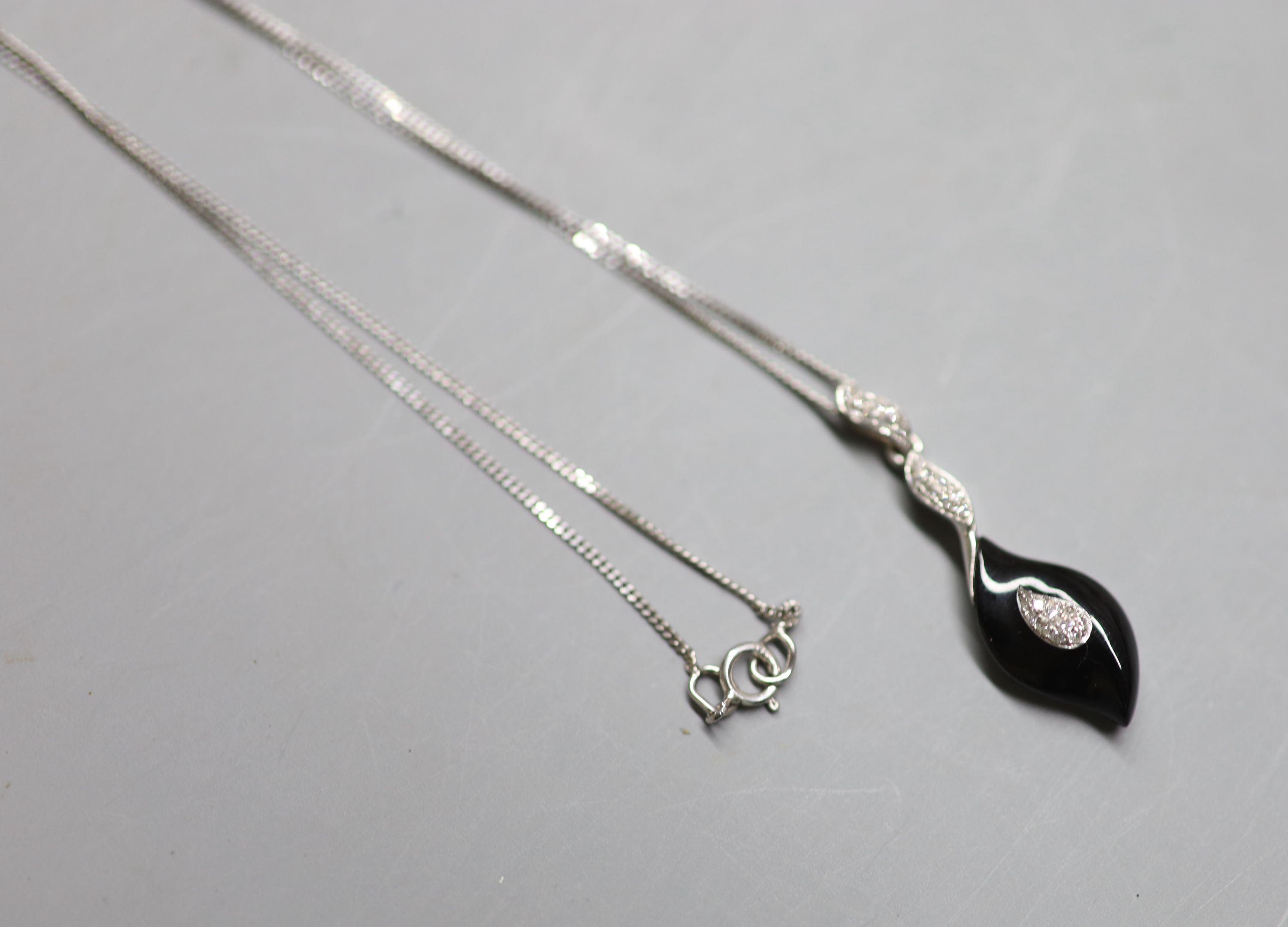 A modern 9ct white gold, black onyx and diamond chip set drop pendant, 31mm, on a 9ct white gold fine link chain